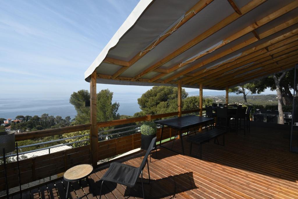 une terrasse en bois avec une table et des chaises dessus dans l'établissement Mobil Home Vue sur Mer - Racine 03, à Saint-Raphaël
