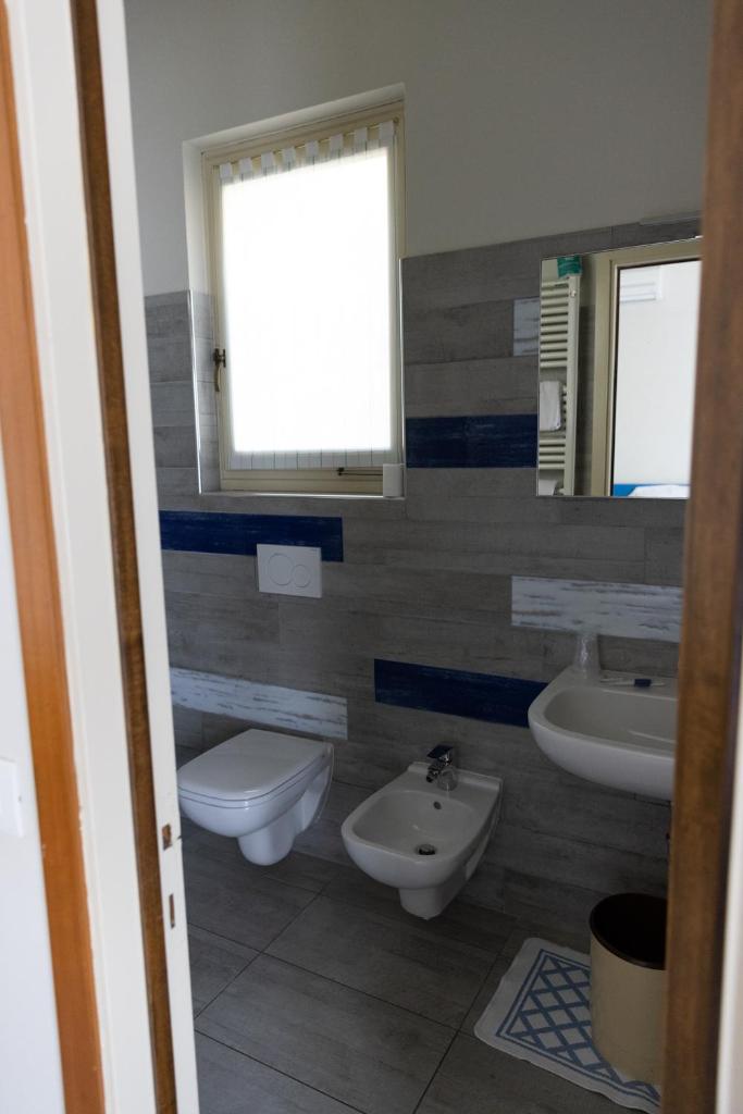 une salle de bain avec deux lavabos et un WC et un miroir dans l'établissement La Foresta Monteisola, à Monte Isola 69 autres photos