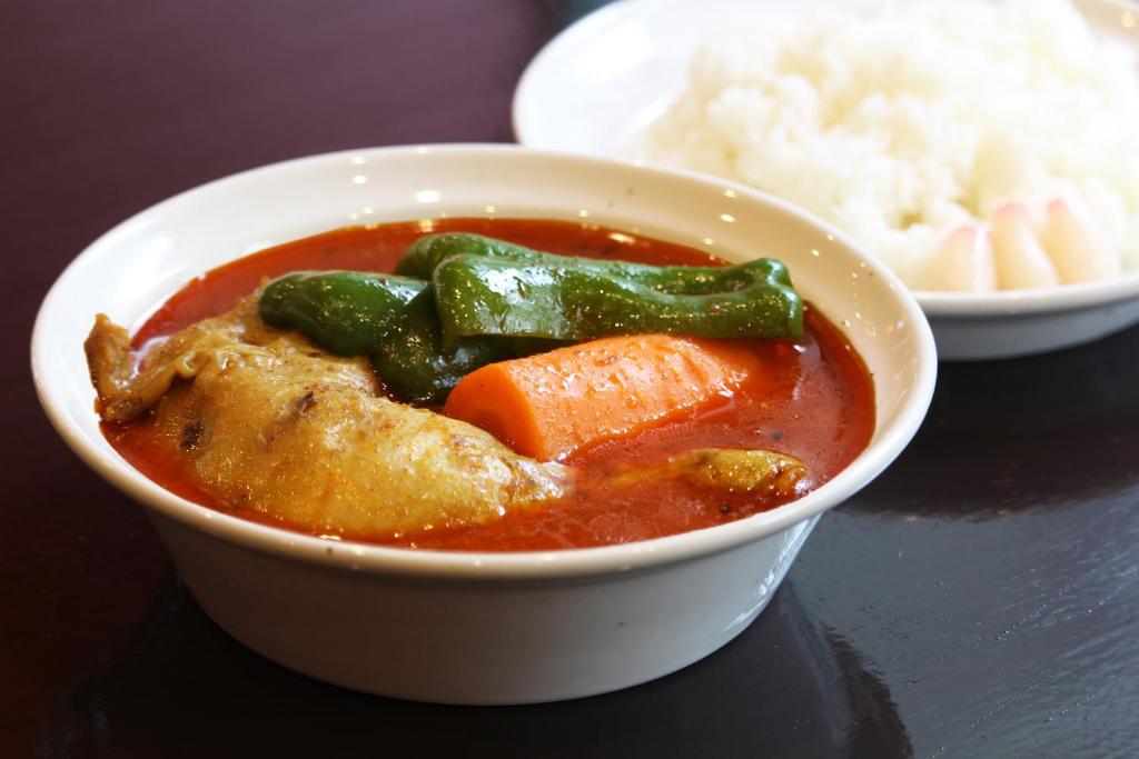 un bol de soupe avec des légumes et du riz sur une table dans l'établissement HOTEL555 錦糸町, à Tokyo 16 autres photos