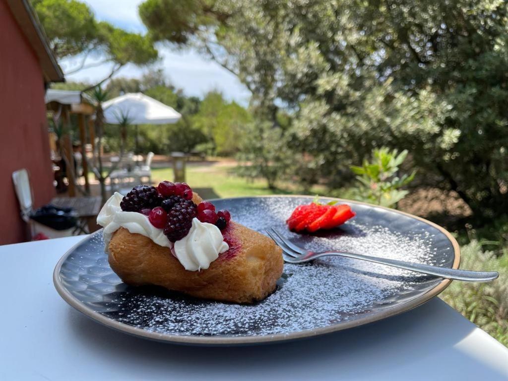 une plaque avec un beignet aux baies et à la crème fouettée dans l'établissement Residence Pineta, à Albinia 55 autres photos
