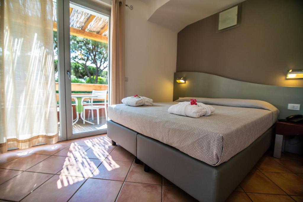 une chambre avec un lit avec deux oreillers dessus dans l'établissement Residence Pineta, à Albinia