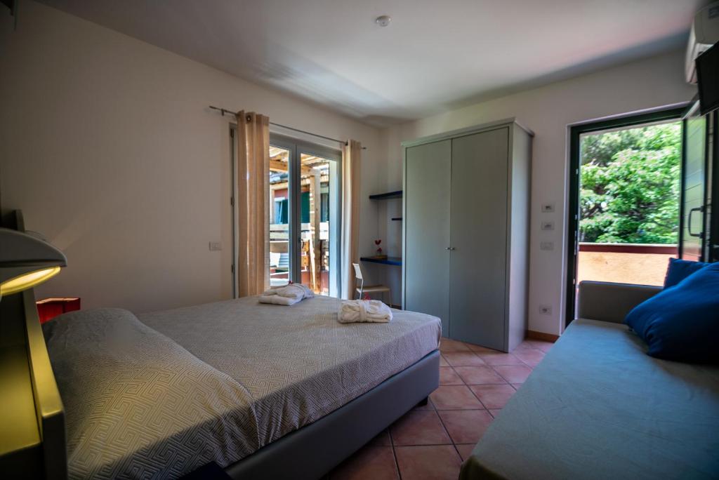 une chambre avec un lit et une porte coulissante en verre dans l'établissement Residence Pineta, à Albinia