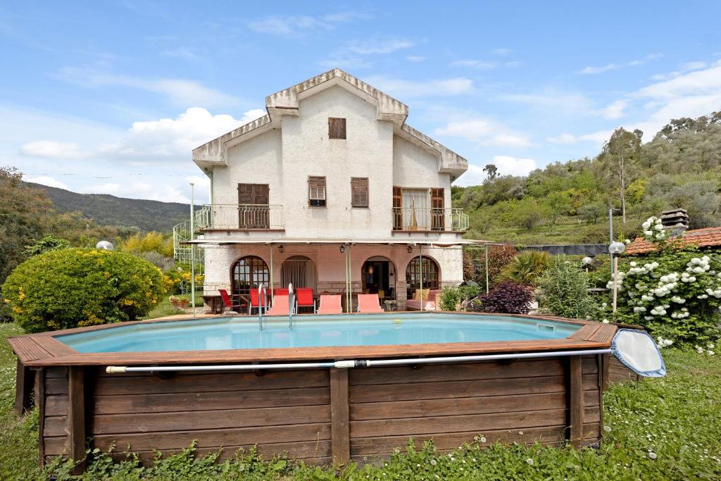 une maison avec une piscine devant une maison dans l'établissement Villa La Casa di Giacomo, à Pigna