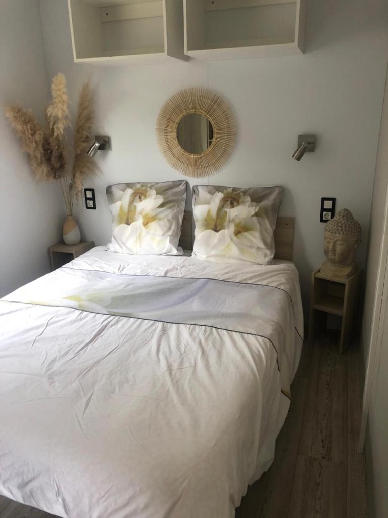 - un lit blanc avec des draps et des oreillers blancs dans une chambre dans l'établissement Mobil Home superbe Vue Mer St Raphaël, à Saint-Raphaël