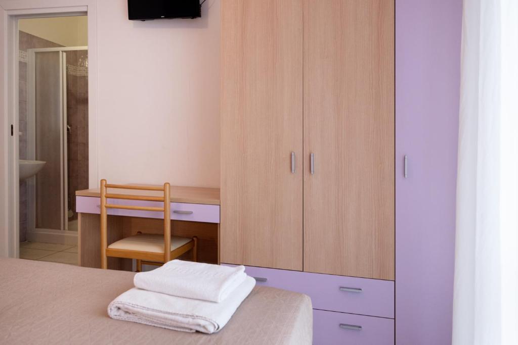 - une chambre avec un lit, un bureau et une armoire dans l'établissement Hotel Giordo, à Rimini
