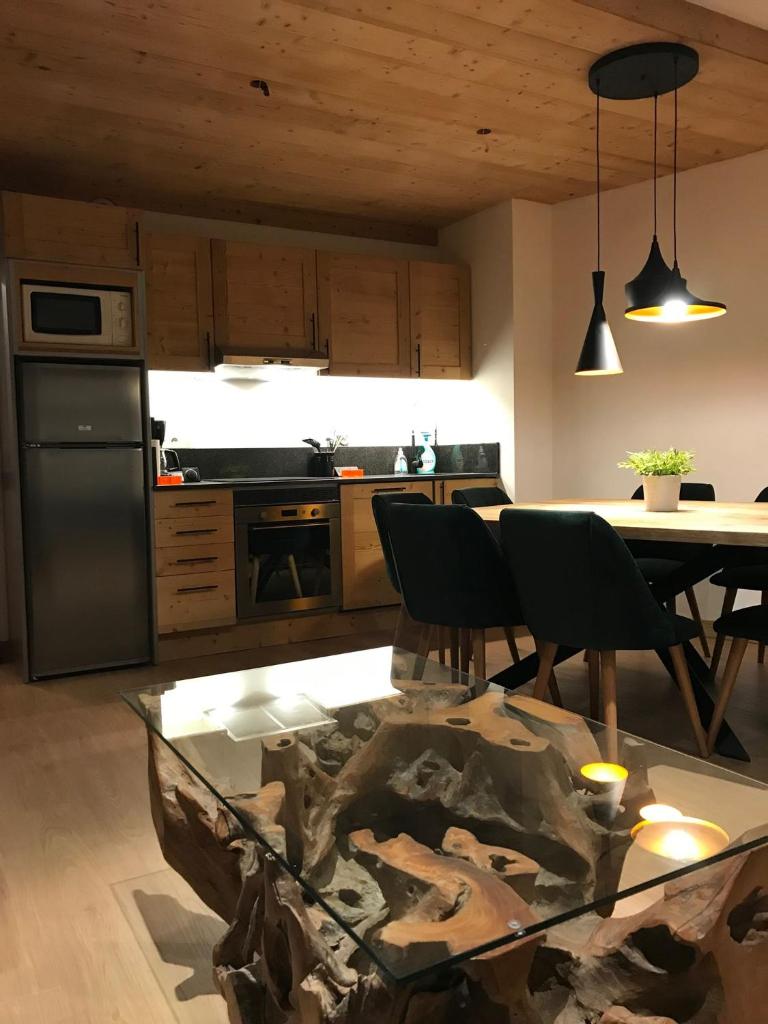 une cuisine avec une table et des chaises et une table et une cuisine dans l'établissement Cocoonabay Appartements, aux Angles