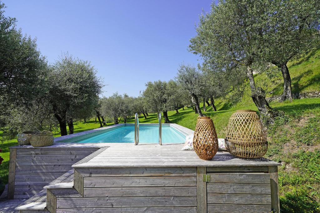 - une piscine avec 2 vases sur une table en bois dans l'établissement Villa Gran Paradiso, à Toscolano Maderno