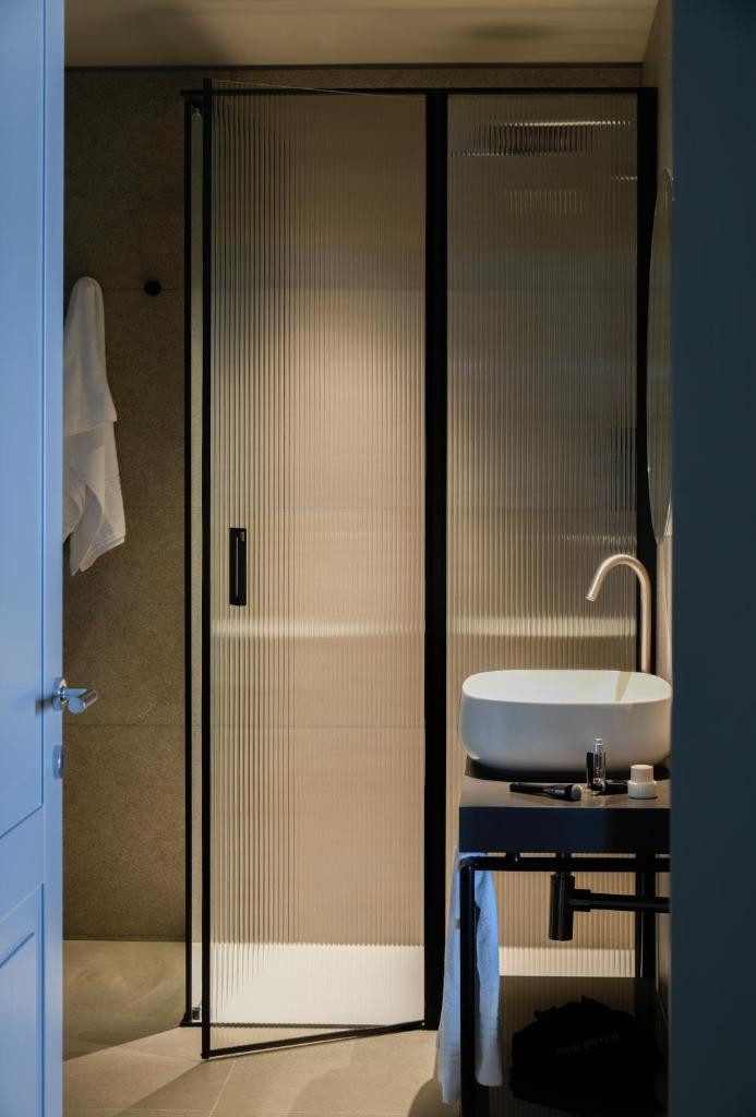 La salle de bains est pourvue d'un lavabo et d'une porte en verre. dans l'établissement Hotel Windsor, à Laigueglia 52 autres photos