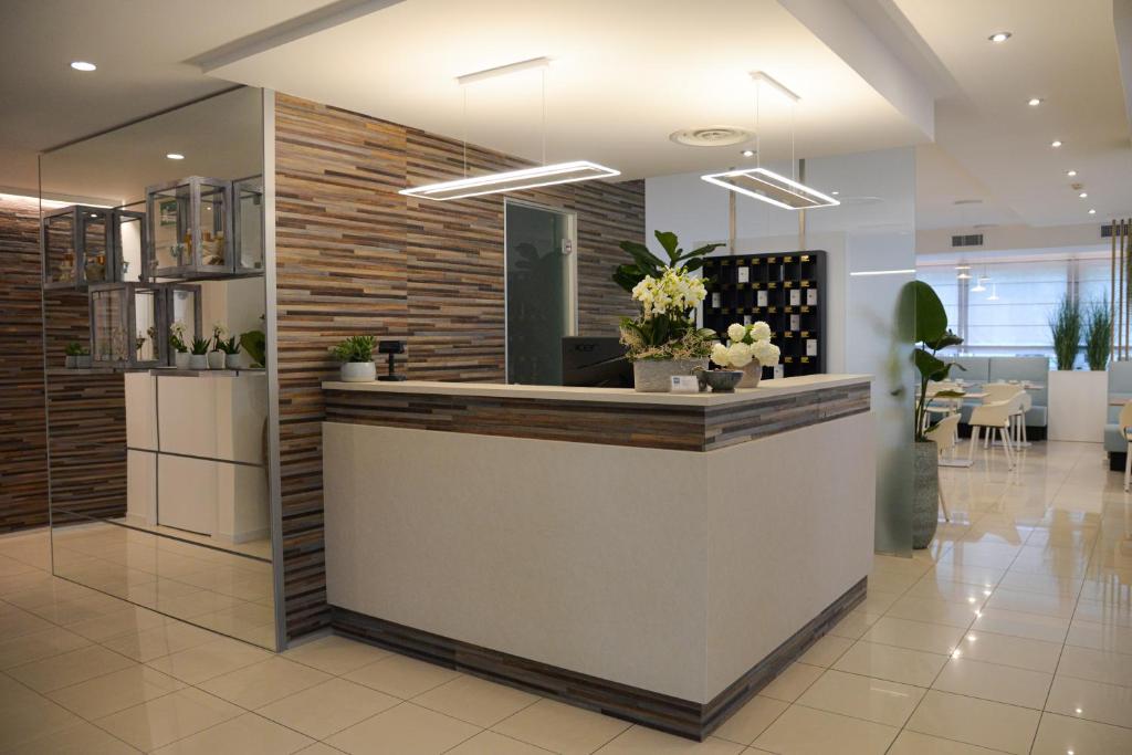 un hall avec un comptoir de réception dans un bâtiment dans l'établissement Hotel Renania, à Bibione