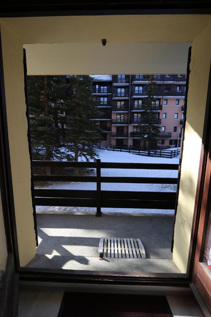 - une vue sur une fenêtre donnant sur un bâtiment dans l'établissement Risoul superbe appartement pieds des pistes, à Risoul