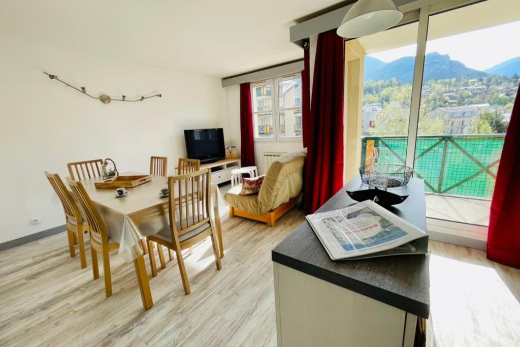 une cuisine et un salon avec une table et des chaises dans l'établissement LUMINEUX 50 m avec BALCON au centre de Briançon, à Briançon