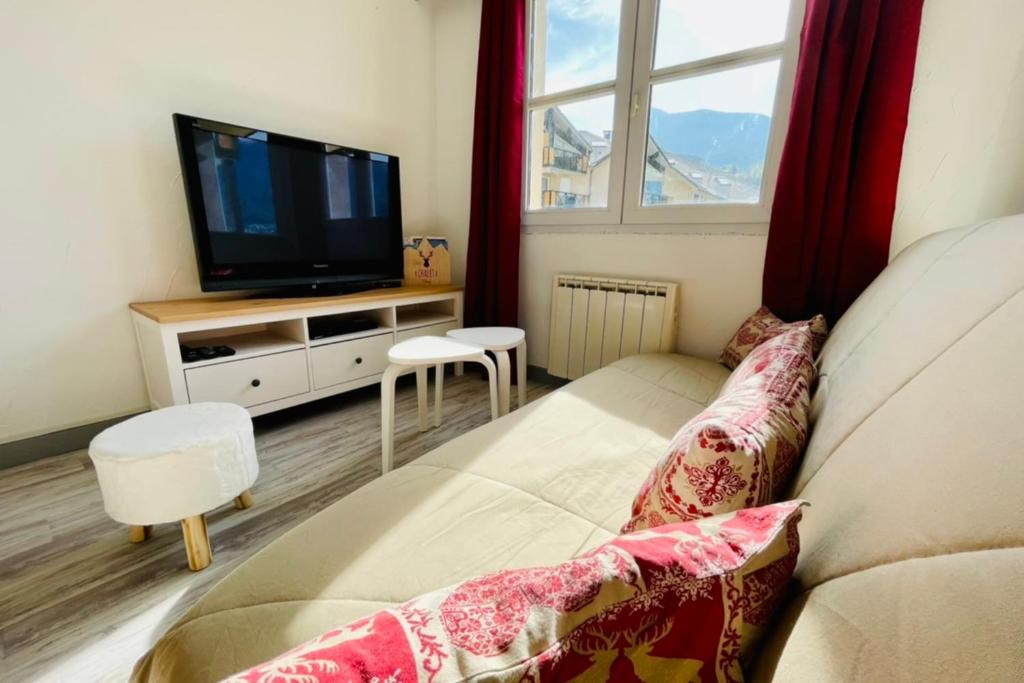 un salon avec un canapé et une télévision dans l'établissement LUMINEUX 50 m avec BALCON au centre de Briançon, à Briançon