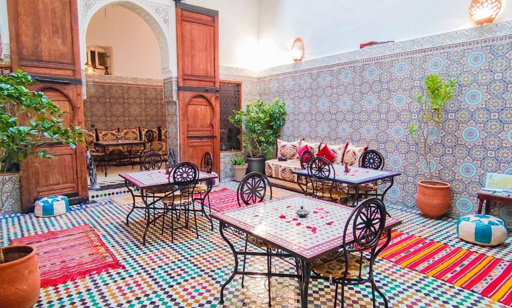 Cette chambre dispose d'une terrasse avec des tables et des chaises. dans l'établissement Riad Fes EL KAID, à Fès