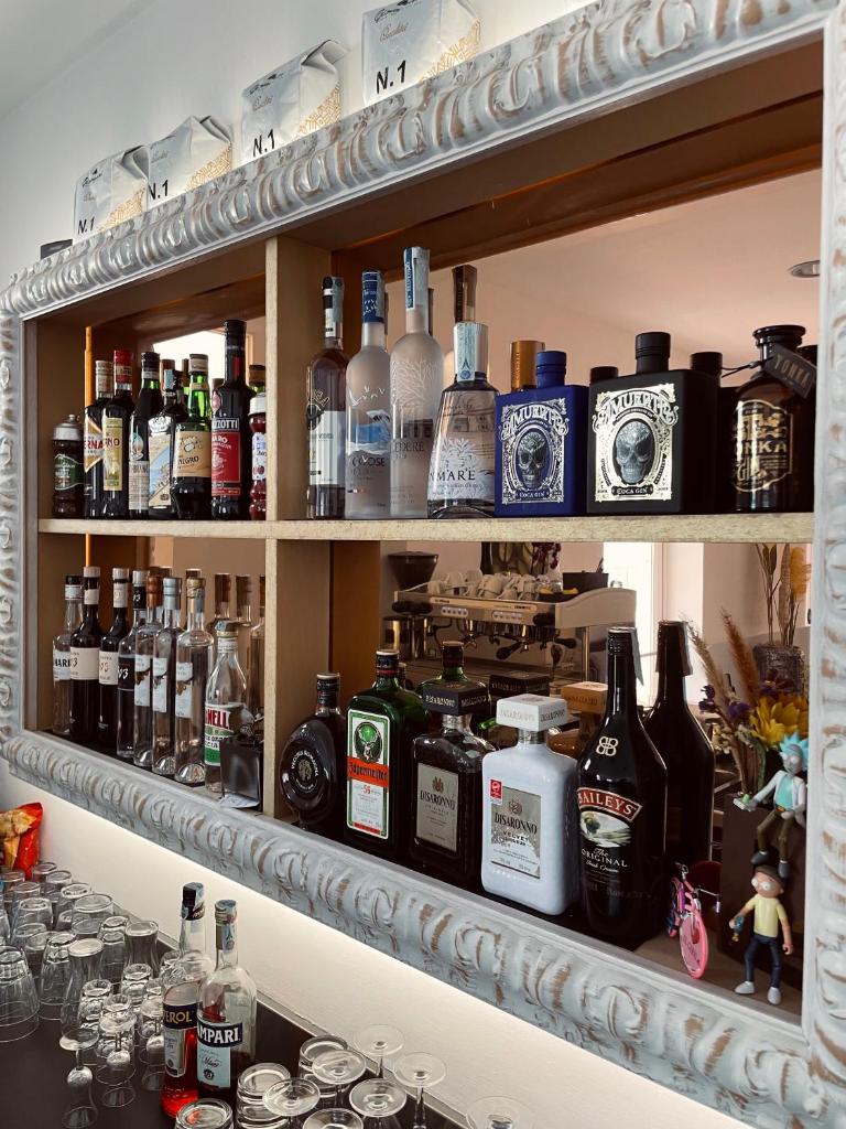 une étagère remplie de bouteilles d'alcool dans l'établissement Hotel Vera, à Cesenatico