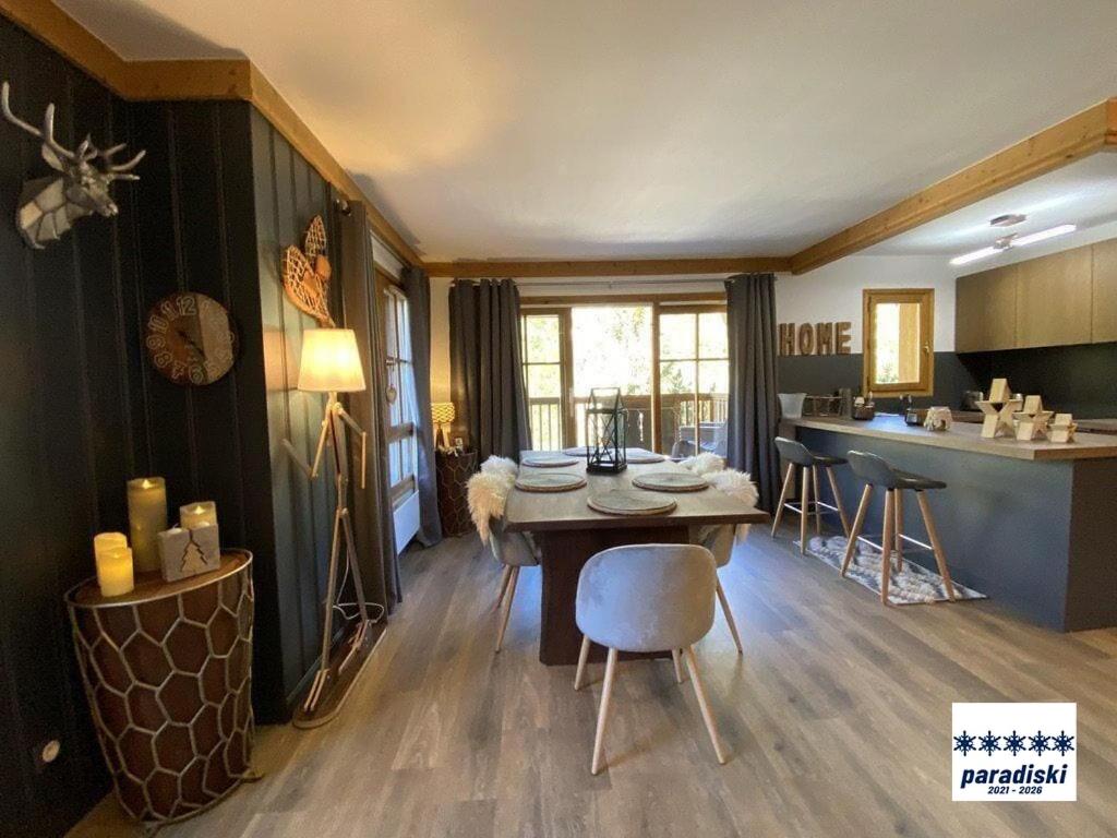 une cuisine et une salle à manger avec une table et des chaises dans l'établissement Stylish ski-in ski-out 3 bed apartment, Arc 1950, à Arc 1950 20 autres photos