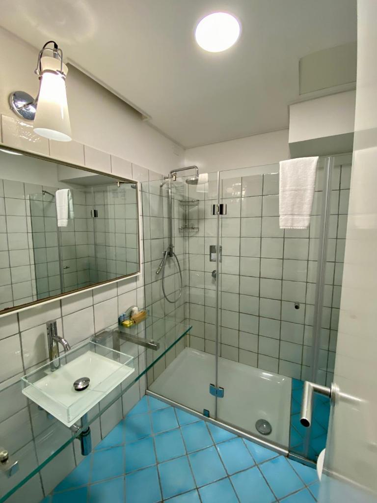 une salle de bain avec douche et lavabo dans l'établissement Ganimede Hotel, à Sperlonga