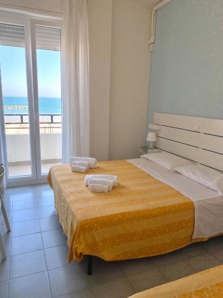 une chambre avec un grand lit avec des serviettes dessus dans l'établissement HOTEL FLYING, à Pesaro 36 autres photos