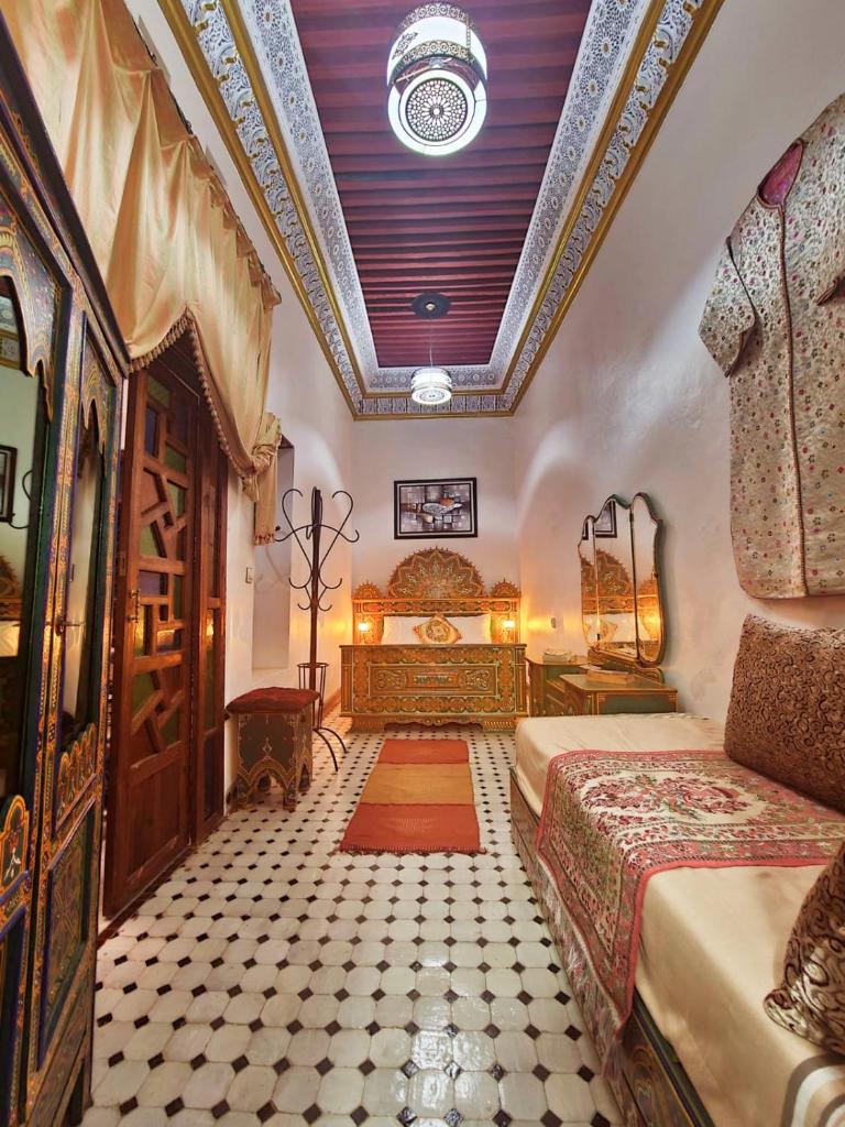 - une chambre avec deux lits et un plafond dans l'établissement Riad Fés blida, à Fès