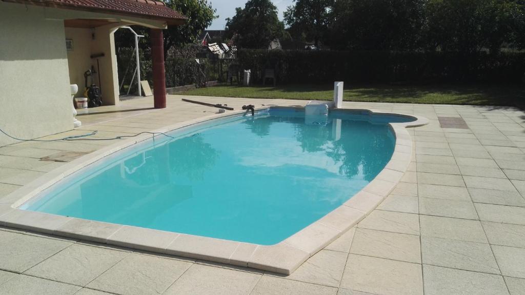 une grande piscine bleue dans une cour dans l'établissement Gite du Berger, à Brouviller
