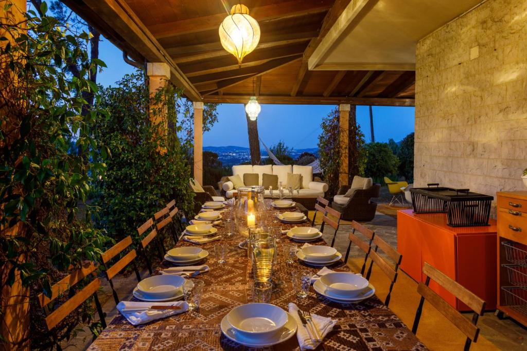 - une grande table avec des chaises et des assiettes dans l'établissement Villa Rosaria by Mmega, à Ripe