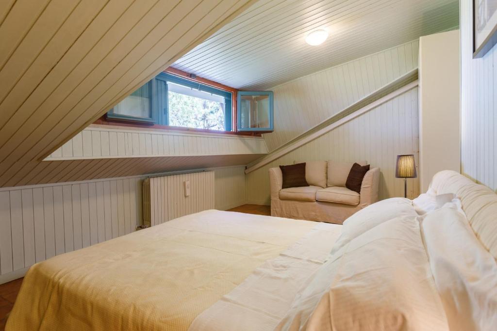 une chambre mansardée avec un lit et une fenêtre dans l'établissement Villa Rosaria by Mmega, à Ripe