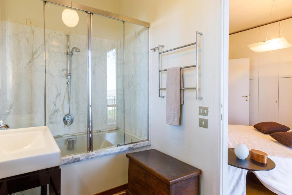 une salle de bain avec une douche et un lavabo et un lit dans l'établissement Villa Rosaria by Mmega, à Ripe