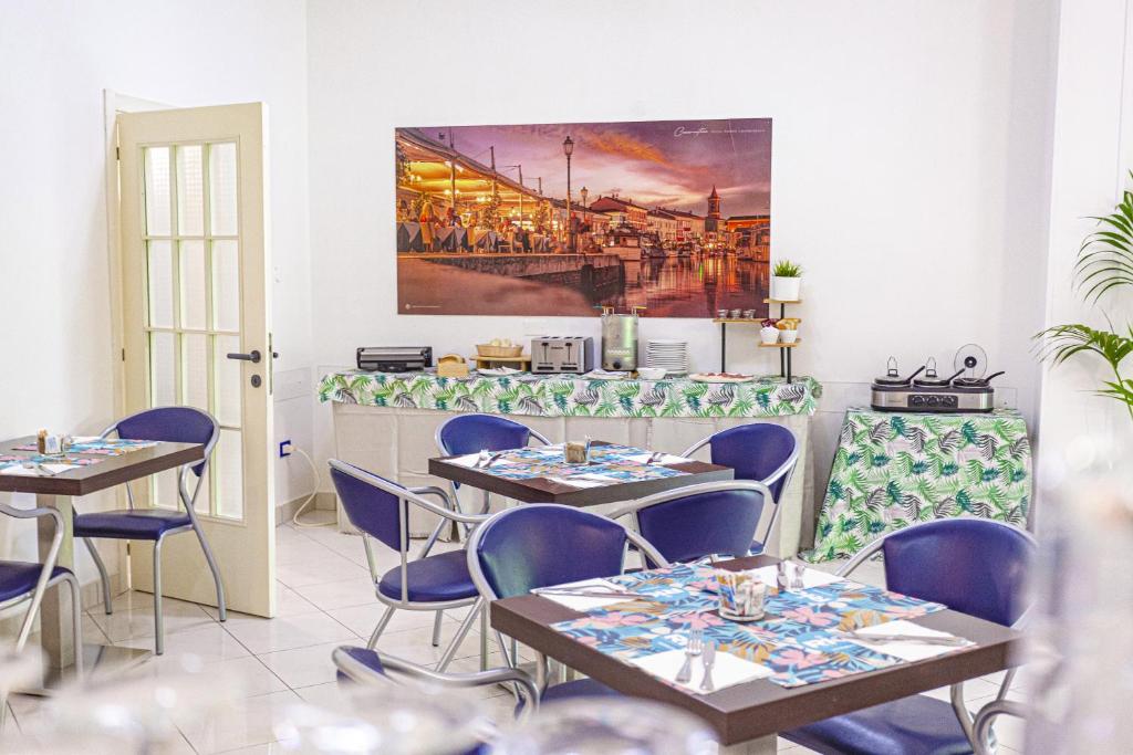 un restaurant avec des tables et des chaises et un tableau au mur dans l'établissement Hotel Rio Beach & Breakfast, à Cesenatico
