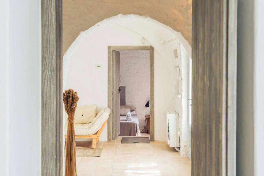 un salon avec une arche et un canapé dans l'établissement Trullo Fragno - Apuliaria Stays, à Martina Franca