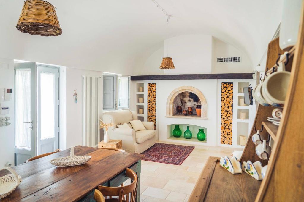 un salon avec une table en bois et un canapé dans l'établissement Trullo Fragno - Apuliaria Stays, à Martina Franca