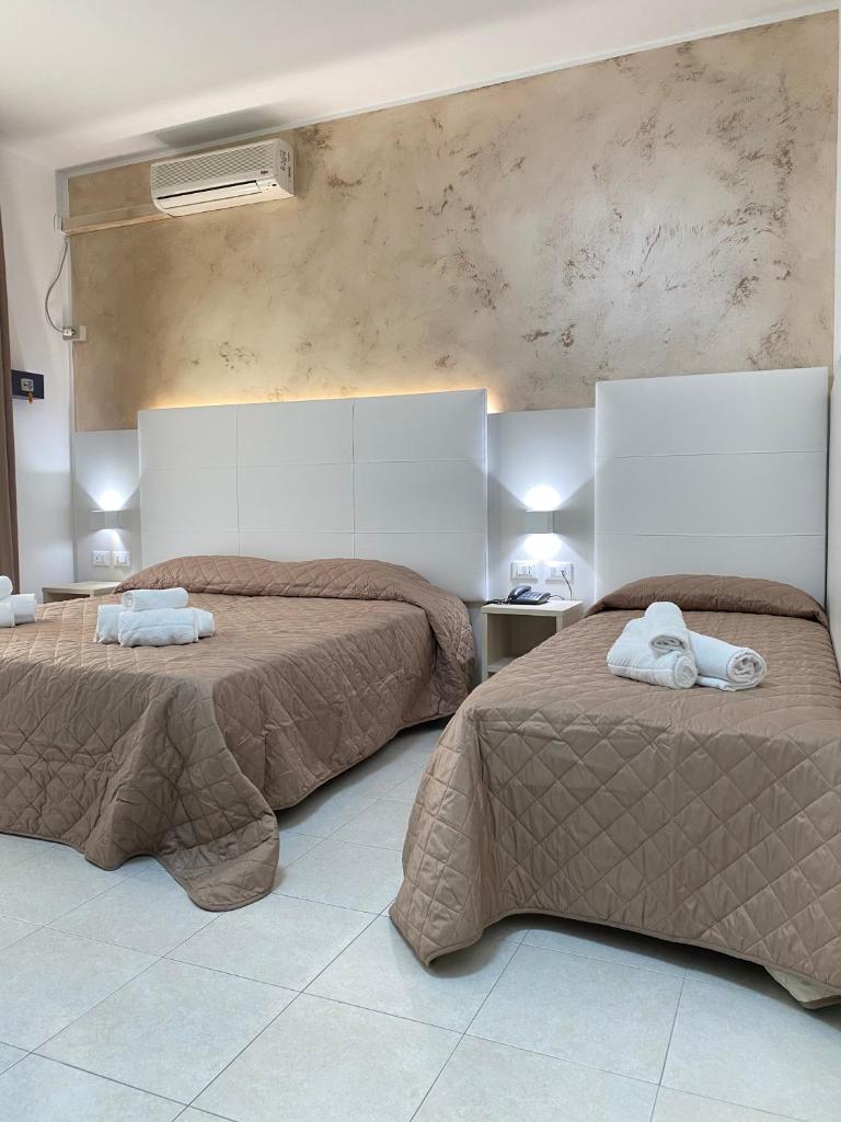 une chambre avec deux lits avec des serviettes dessus dans l'établissement Hotel Bahia, à Caorle