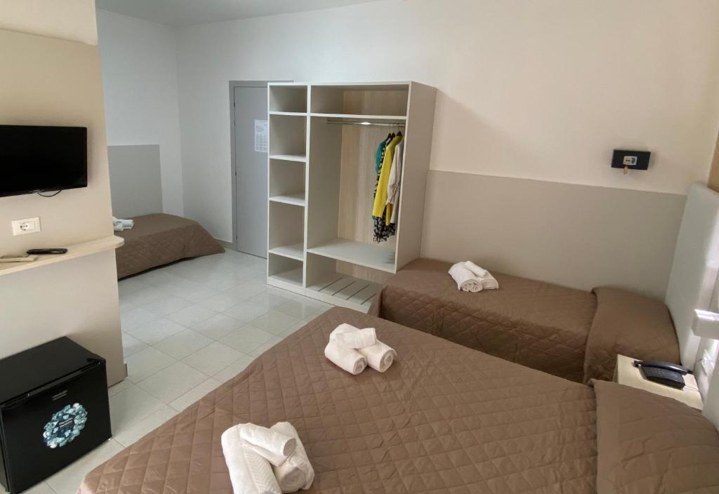 une petite chambre avec deux lits et une télévision dans l'établissement Hotel Bahia, à Caorle