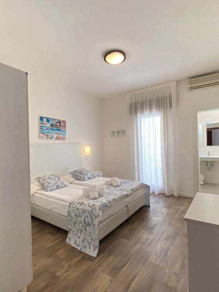 une chambre avec un grand lit dans une pièce dans l'établissement Hotel Linda, à Caorle