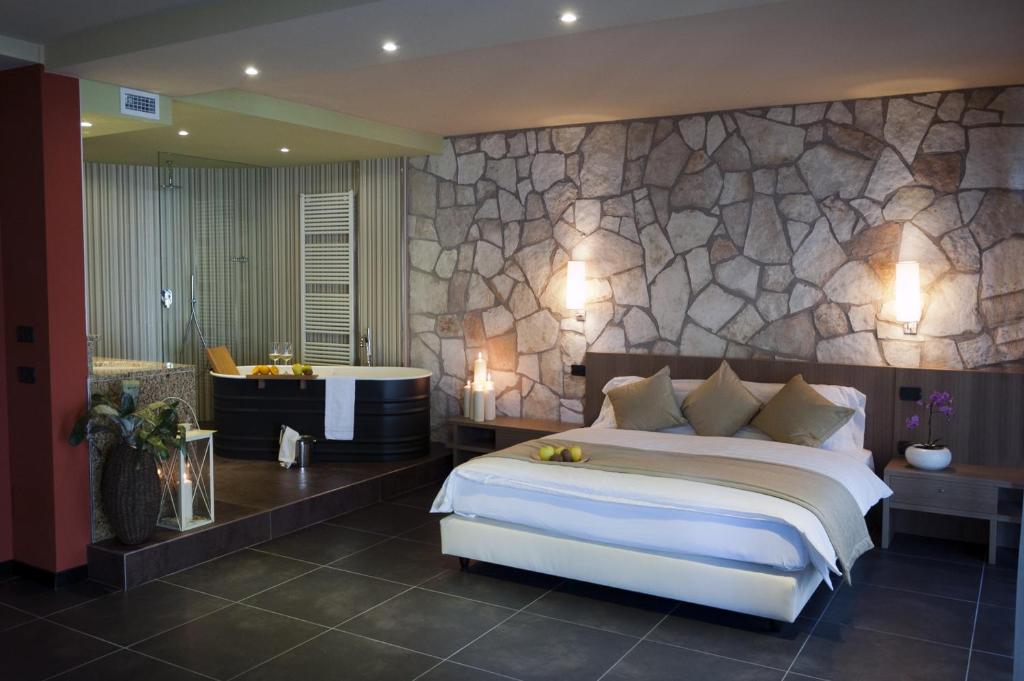 une chambre avec un grand lit et une baignoire dans l'établissement Hotel Du Lac - Relax Attitude Hotel, à Brenzone 105 autres photos