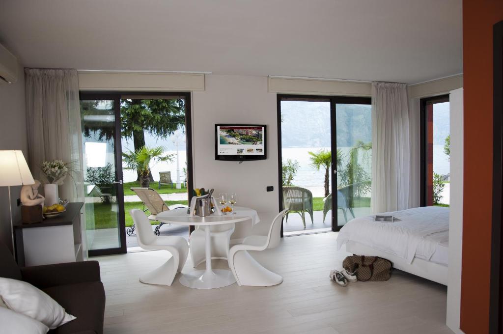 - une chambre avec une table blanche, des chaises et un lit dans l'établissement Hotel Du Lac - Relax Attitude Hotel, à Brenzone