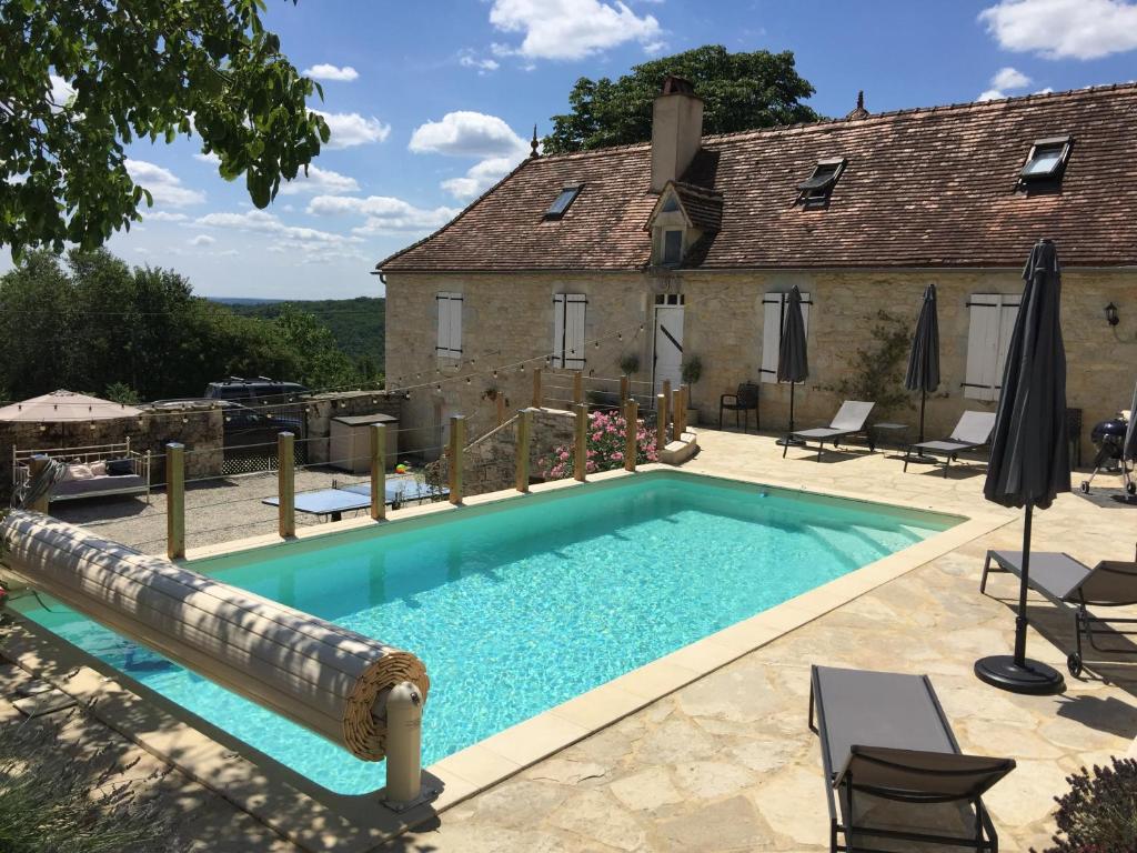 - une piscine avec toboggan en face d'une maison dans l'établissement Safari tent lodges with a beautiful view at Lot Sous Toile, à Montamel