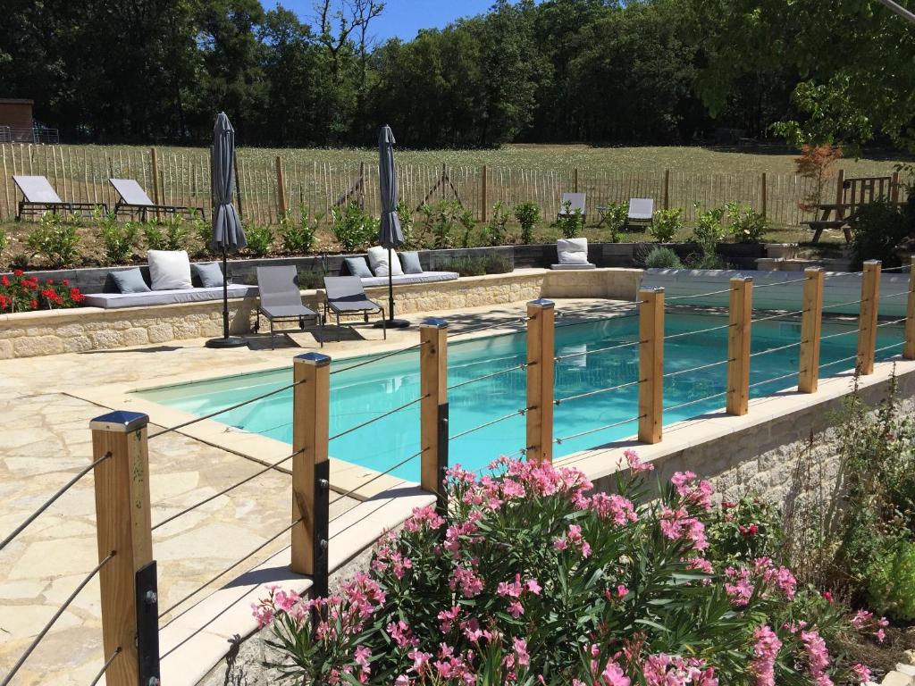 - une piscine avec des chaises, des parasols et des fleurs dans l'établissement Safari tent lodges with a beautiful view at Lot Sous Toile, à Montamel
