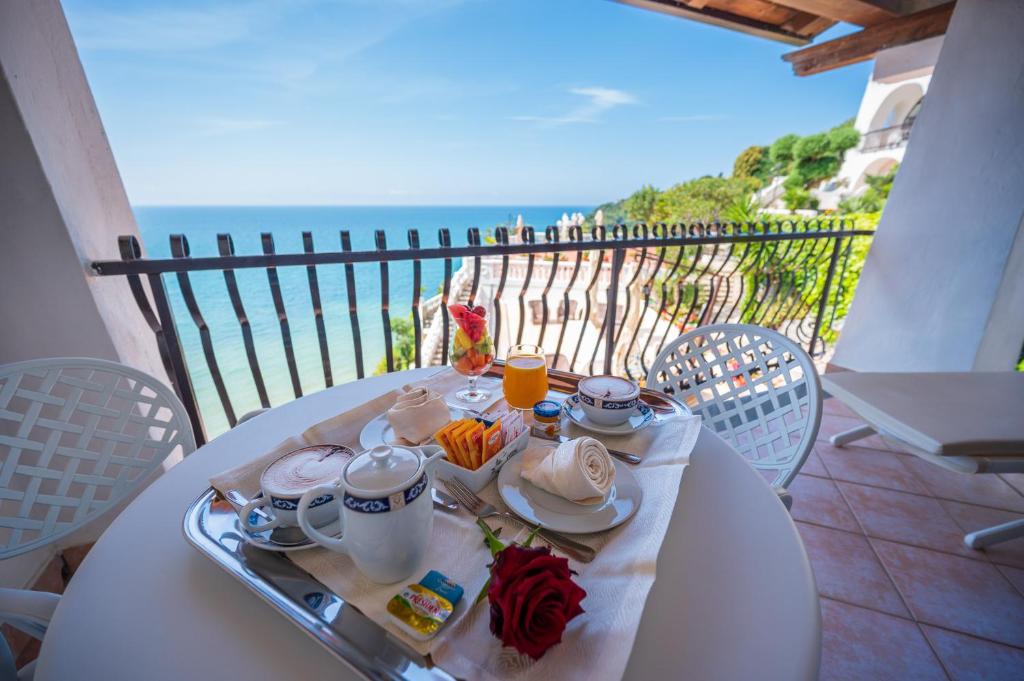 une table blanche avec une assiette de nourriture sur un balcon dans l'établissement Grand Hotel Le Rocce, à Gaète