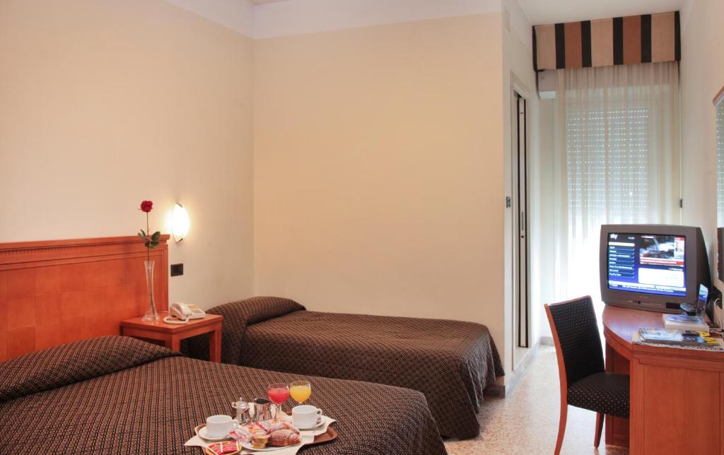 une chambre d'hôtel avec deux lits et une télévision dans l'établissement Nautilus, à Riccione