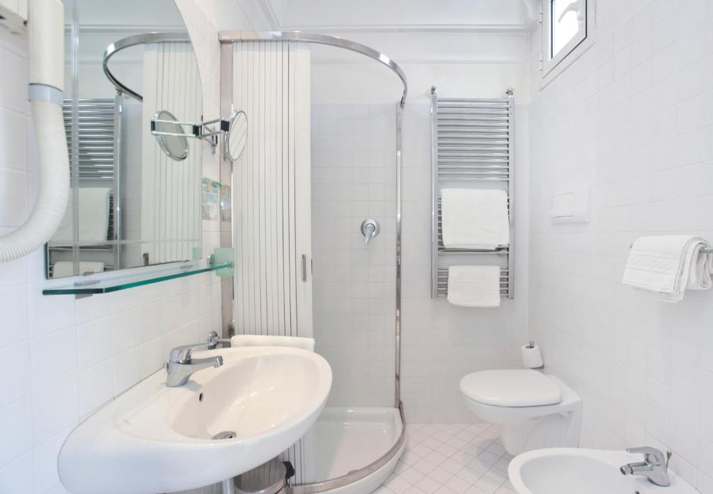une salle de bain blanche avec un lavabo et des toilettes dans l'établissement Nautilus, à Riccione