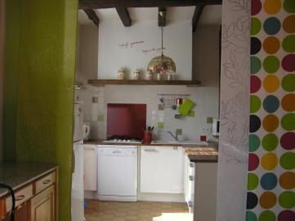 une cuisine avec des armoires blanches et des murs verts dans l'établissement Gîte Champêtre avec Piscine Chauffée, Cheminée, et Terrasse en Plein Sud - FR-1-410-131, à La Chapelle-aux-Choux