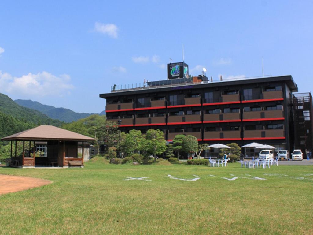 un grand bâtiment avec des tables et des chaises dans un champ dans l'établissement LiVEMAX RESORT Kinugawa, à Nikkō