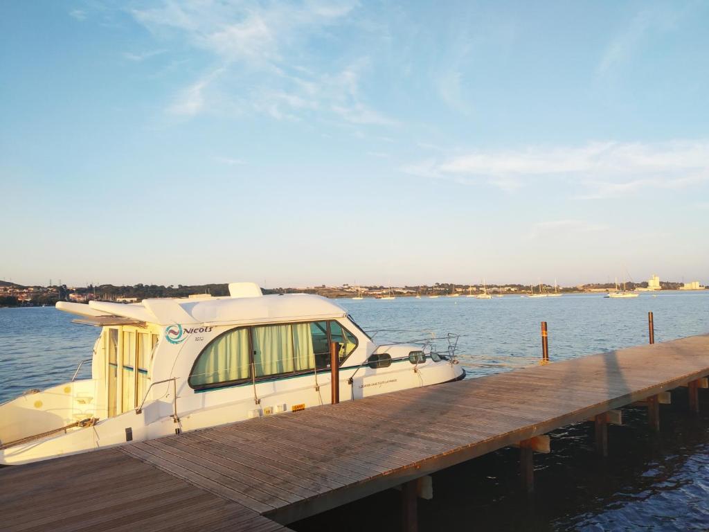 un bateau est amarré à un quai dans l'établissement Bateau 6 personnes sans permis terrasse à quai ou option navigation, à Béziers