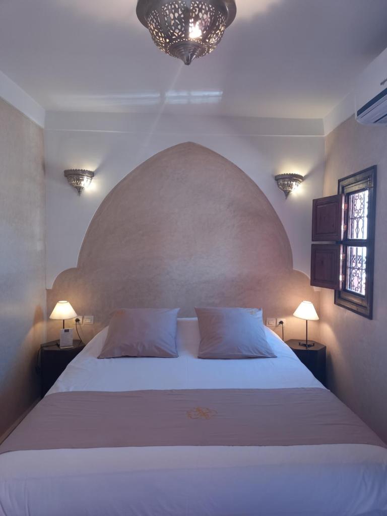 une chambre avec un grand lit blanc avec deux oreillers dans l'établissement Riad CHERRATA, à Marrakech
