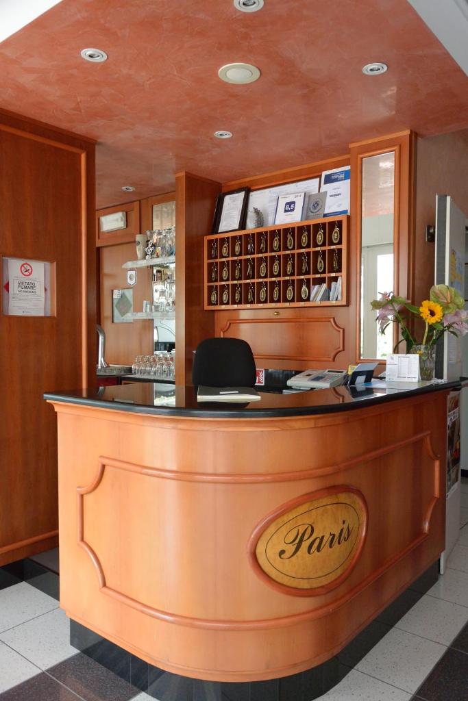 - un bar dans un restaurant avec un panneau d'affichage dans l'établissement Hotel Paris, à Lignano Sabbiadoro