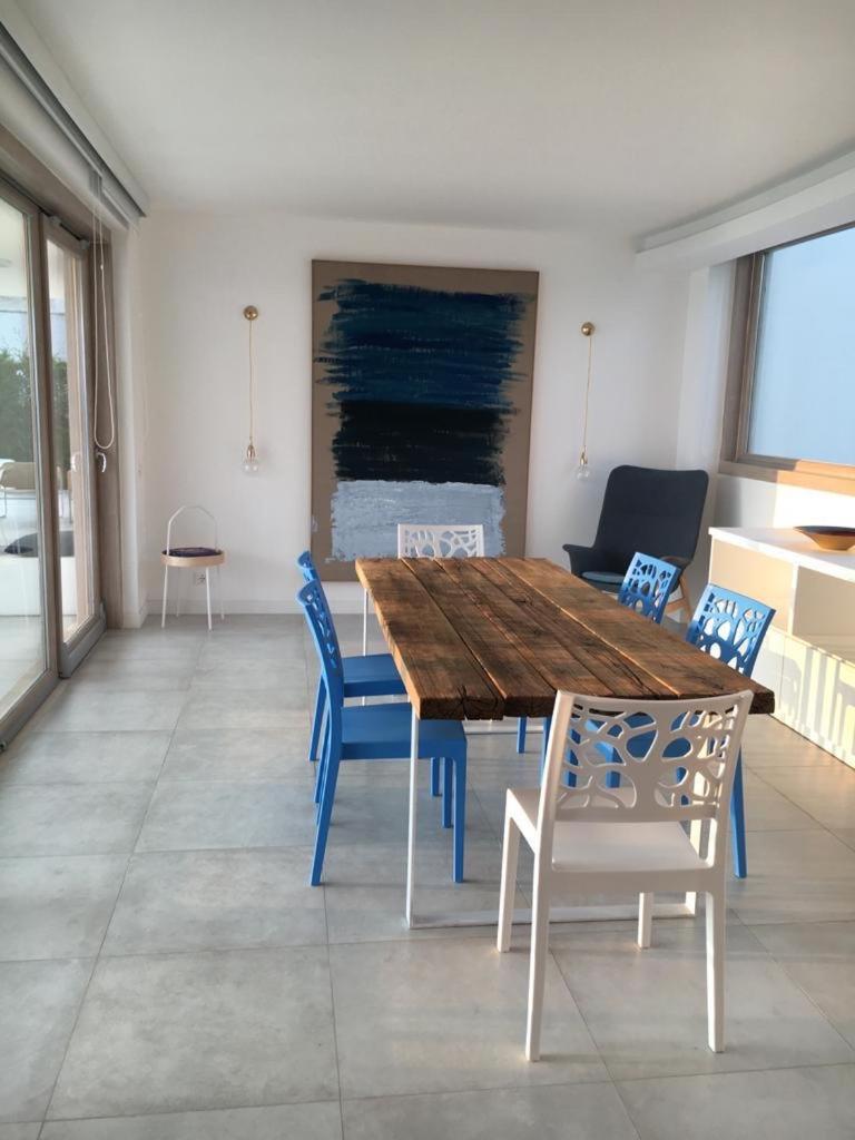 une salle à manger avec une table en bois et des chaises bleues dans l'établissement Luxury villa Blue&Blanc piscina a sfioro isola, à Diamante 18 autres photos