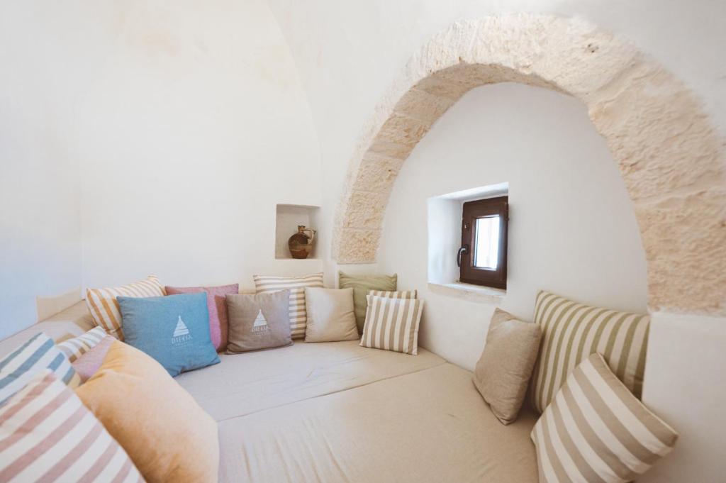 un salon avec un canapé avec des oreillers dans l'établissement Trulli Difesa, à Martina Franca