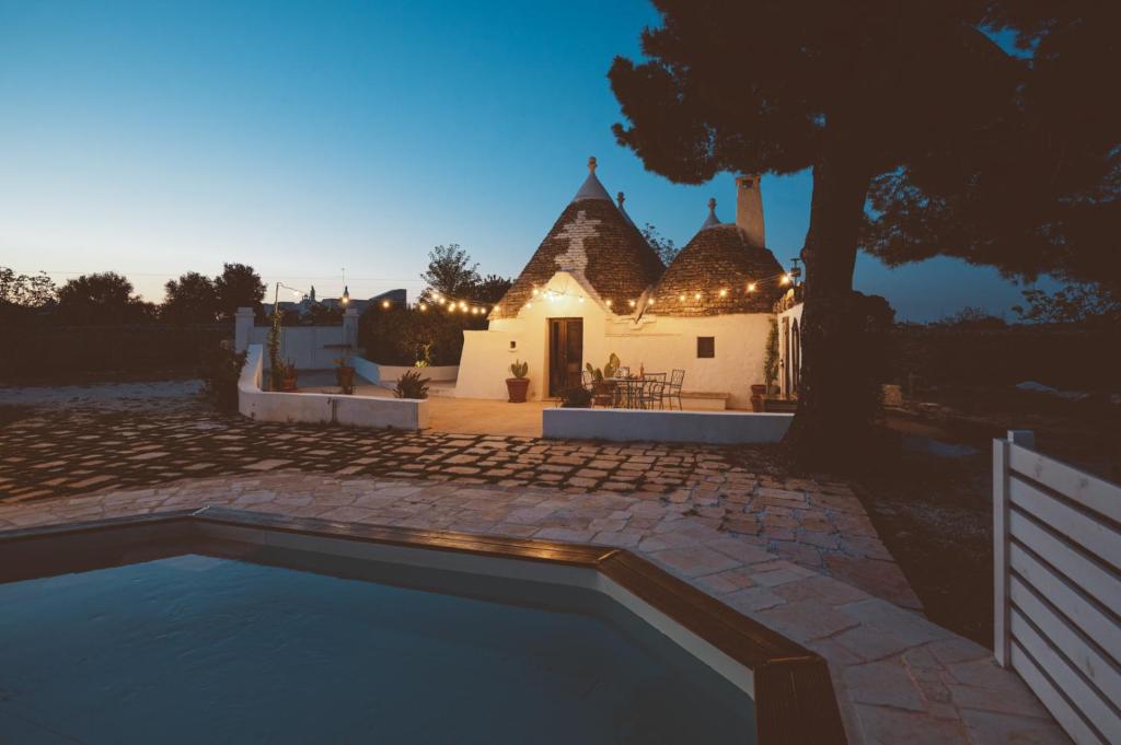une villa avec piscine devant une maison dans l'établissement Trulli Difesa, à Martina Franca