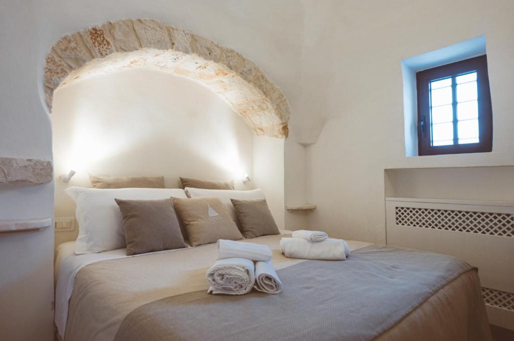 une chambre avec un grand lit avec deux serviettes dessus dans l'établissement Trulli Difesa, à Martina Franca