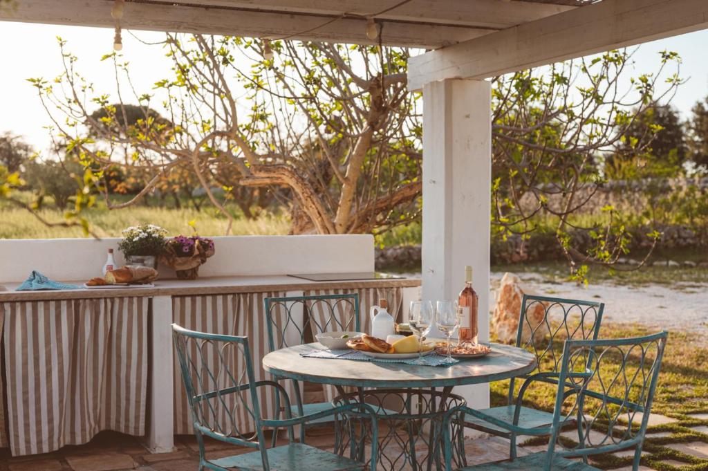 une table et des chaises assises sur une terrasse dans l'établissement Trulli Difesa, à Martina Franca