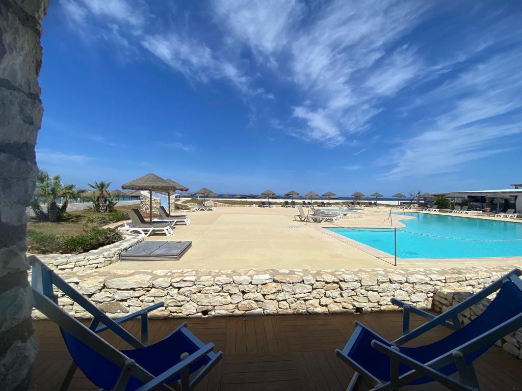 - deux chaises bleues et une piscine dans l'établissement Baia dei Mulini Resort & Spa, à Trapani